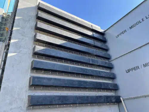 Rows of extruded square rubber fenders mounted on a concrete marine structure for berth wall protection.