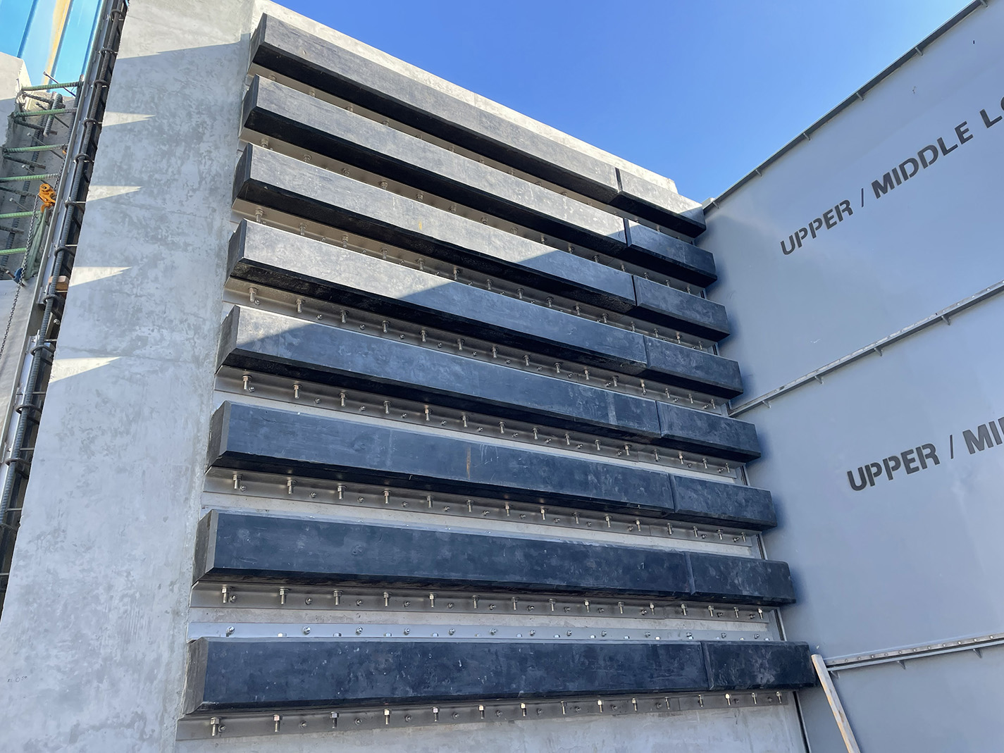 Rows of extruded square rubber fenders mounted on a concrete marine structure for berth wall protection.